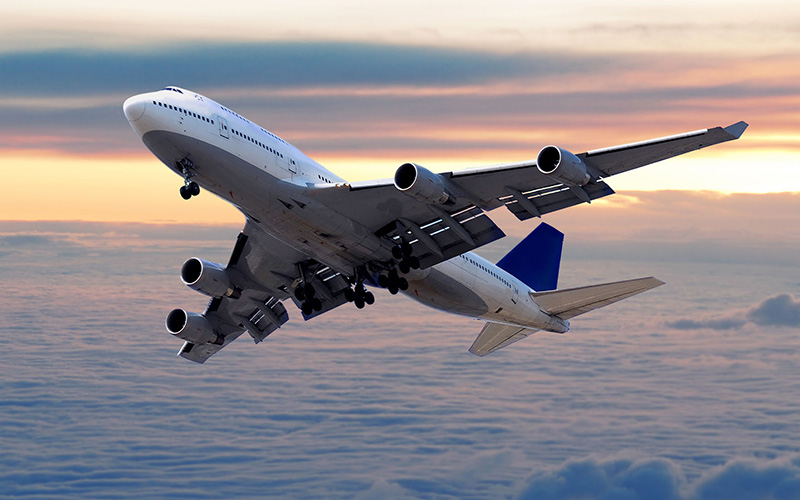 Commercial Airliner Flying Above Clouds